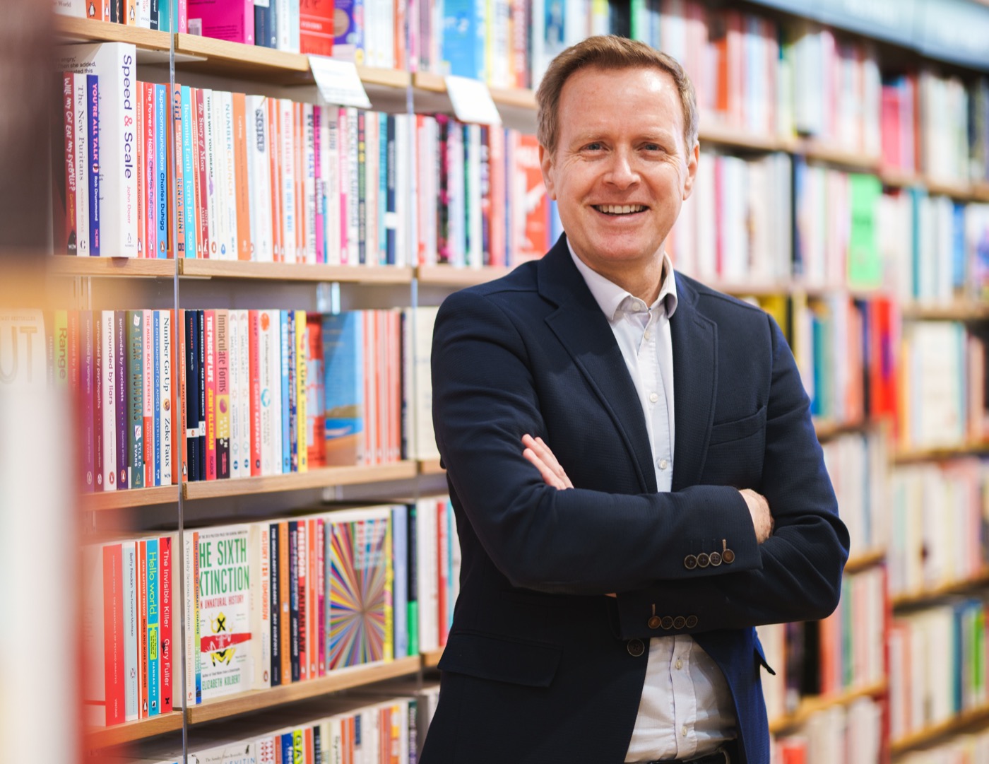 Jaime Roca standing in front of a bookshelf